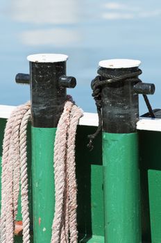 Close-up of a mooring bitt with worn-out rope on a boat