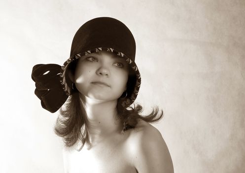 Portrait of a young girl in hat in studio