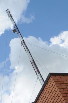 The aerial of mobile communication on a roof of a construction from a red brick