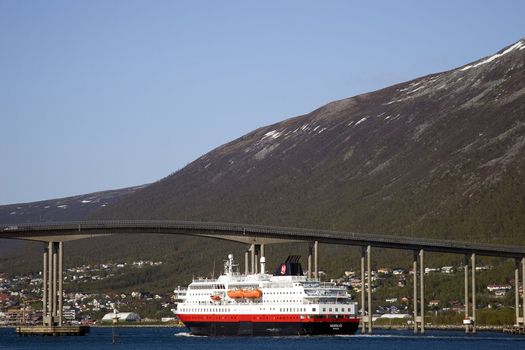 The hurtigruten ship in Tromso, Norway. Passing under one of the bridges that connect Tromso city with the mainland.