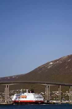 The hurtigruten ship in Tromso, Norway. Passing under one of the bridges that connect Tromso city with the mainland.