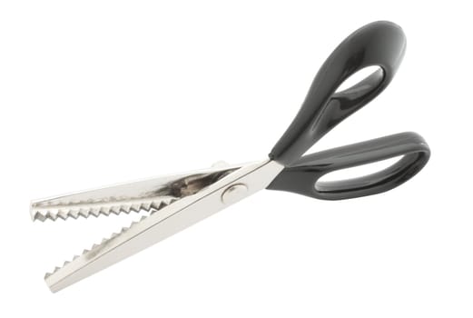Steel scissors with the black plastic handle cutting a zigzag