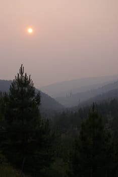 Sun setting behind forest fire smoke in the California Sierra's
