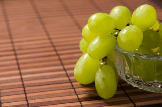 Juicy green grape on a glass vase