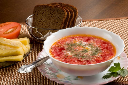 Vegetarian soup, china plate, tomato, cheese, rye bread