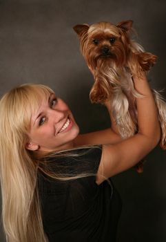 The girl holds the puppy of the yorkshire terrier
