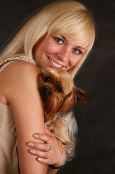 The girl holds the puppy of the yorkshire terrier