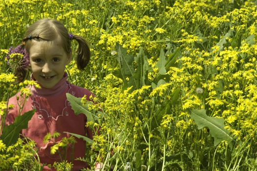 The girl in a pink dress plays yellow colors