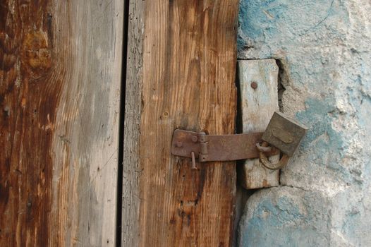 Details of a rusty old lock and wooden dour