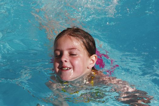 girl having fun just floating in a pool