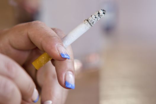 a cigarette in a woman's hand