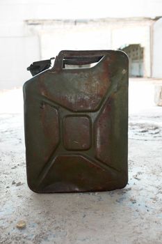 a green jerry can on concrete floer.