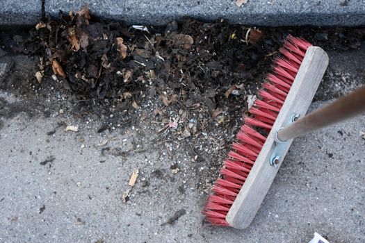 sweeping the sidewalk with a broom