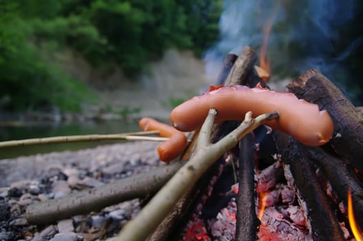 a sausage grilled on a camp fire