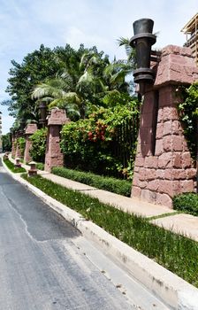 Walkway beside the fence, steel and stone walls of the hotel.