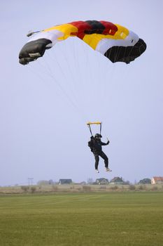 WROCLAW, POLAND - APRIL 3: Undefined parachute jumper starts new season on April 3, 2011. Jumper slows down for landing on green airfield.
