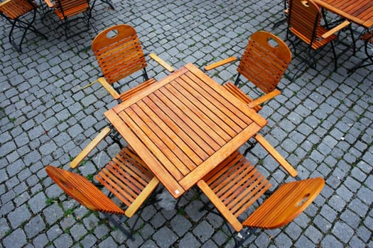 Picture of some wooden seats and tables outside..