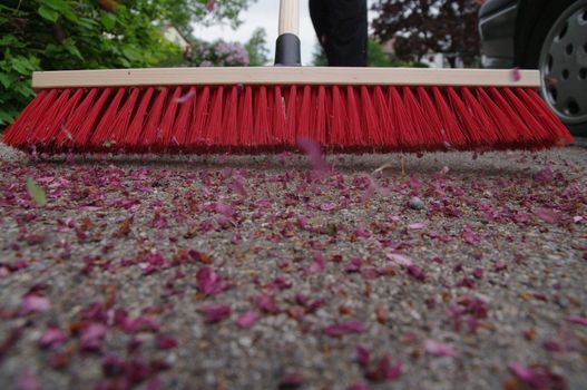 sweeping the sidewalk with a broom