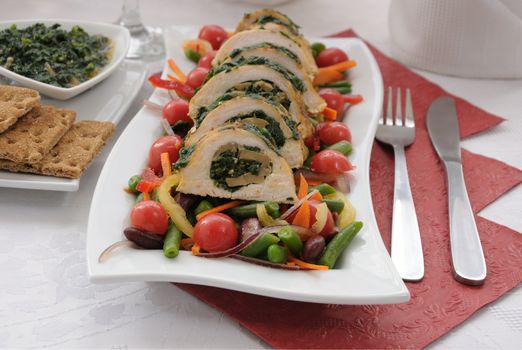 Sliced chicken roll with spinach and mushroom salad with vegetables