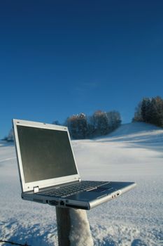 Laptop in a snowy winter landscape scene