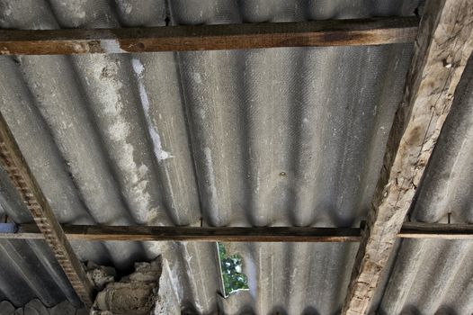 Broken absbestos roofing inside an abandoned house. Hazardous material.