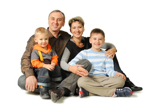 Happy family. The daddy, mum, two sons. It is isolated on a white background.