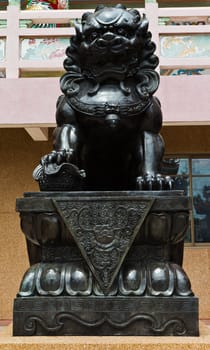 The statues metal lion at the Chinese temple in the daytime.