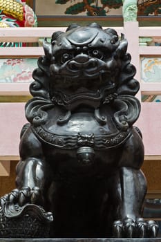 The statues metal lion at the Chinese temple in the daytime.