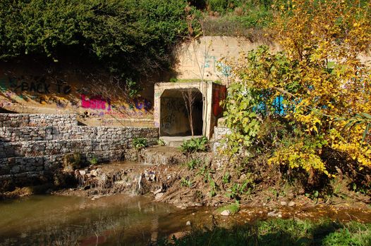 Waste water and sludge from a drain contaminating a small river.