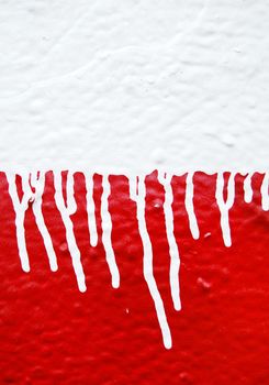 Wall with white dripping paint running over red background. Abstract texture.