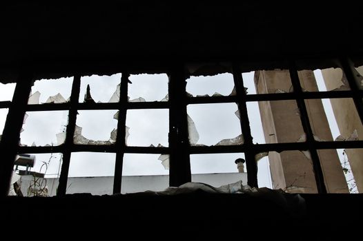 Broken window in a partially demolished abandoned factory.