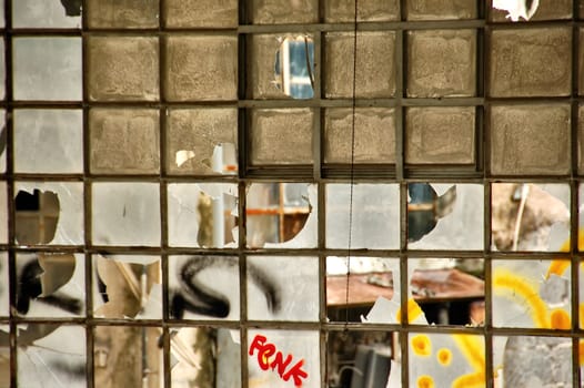 Broken windows in a partially demolished abandoned factory.