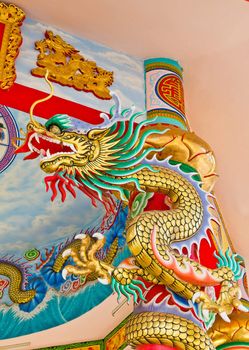 A statue of a dragon on a pole in the Chinese temple in the daytime.