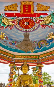 A statue of a dragon on a pole in the Chinese temple in the daytime.