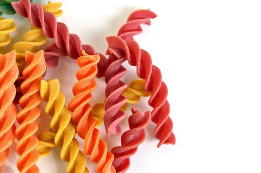 Colorful fusilli pasta. Italian food flavors on white background.