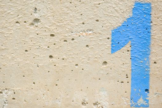 Number one stencil sprayed on rough concrete surface. Background texture.