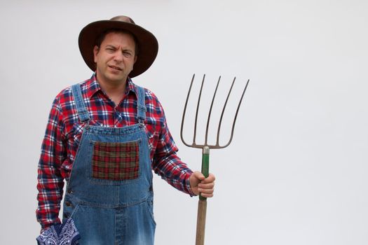 Hillbilly or farmer stands with a pitchfork.