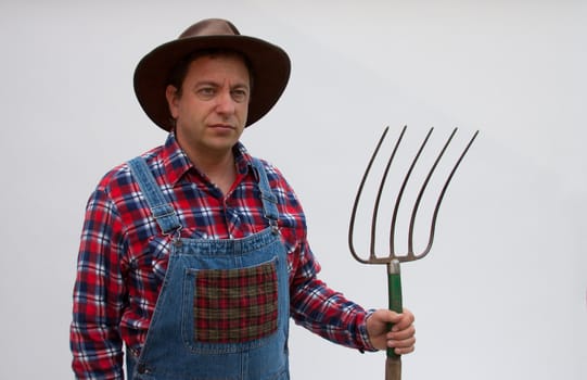 A hillbilly or farmer standing with a pitchfork.