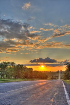 Road and sunset. An automobile line and a red sunset