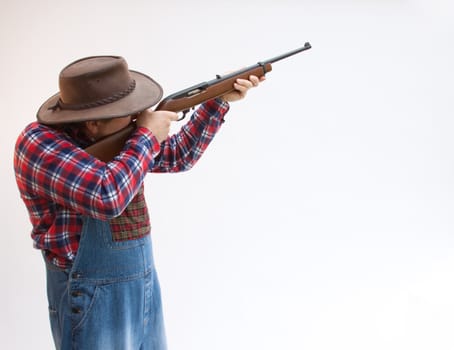 A hillbilly or farmer is taking aim with his rifle.