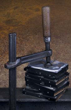 clamp pressing on stack of hard drives. The top drive is deformed
