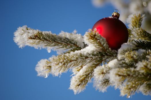 red bauble christmas ball ornament outside in a snowy winter scene