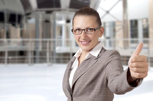 Happy businesswoman showing his thumb up with smile, office background