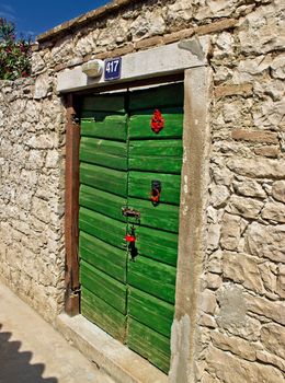 Green traditional door on stone wall, Island of  Susak, Croatia