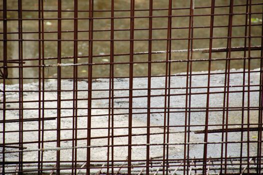 Rusty metal wire mesh fencing panel at construction site. Abstract background.