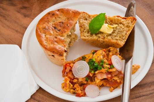 Homemade mediterranean bread with butter scrambled eggs and a leaf of basil