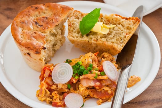 Homemade mediterranean bread with butter scrambled eggs and a leaf of basil