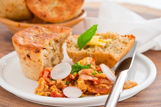 Homemade mediterranean bread with butter scrambled eggs and a leaf of basil