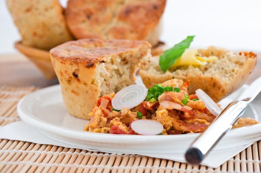 Homemade mediterranean bread with butter scrambled eggs and a leaf of basil