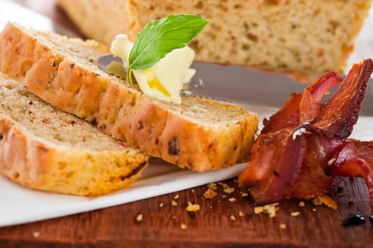 Homemade mediterranean bread with butter bacon and a leaf of basil